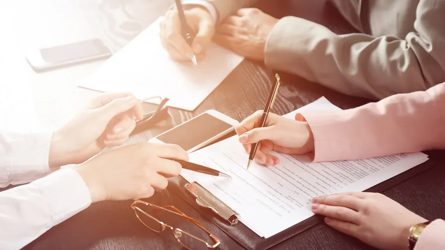 Plusieurs personnes examinent et signent un document